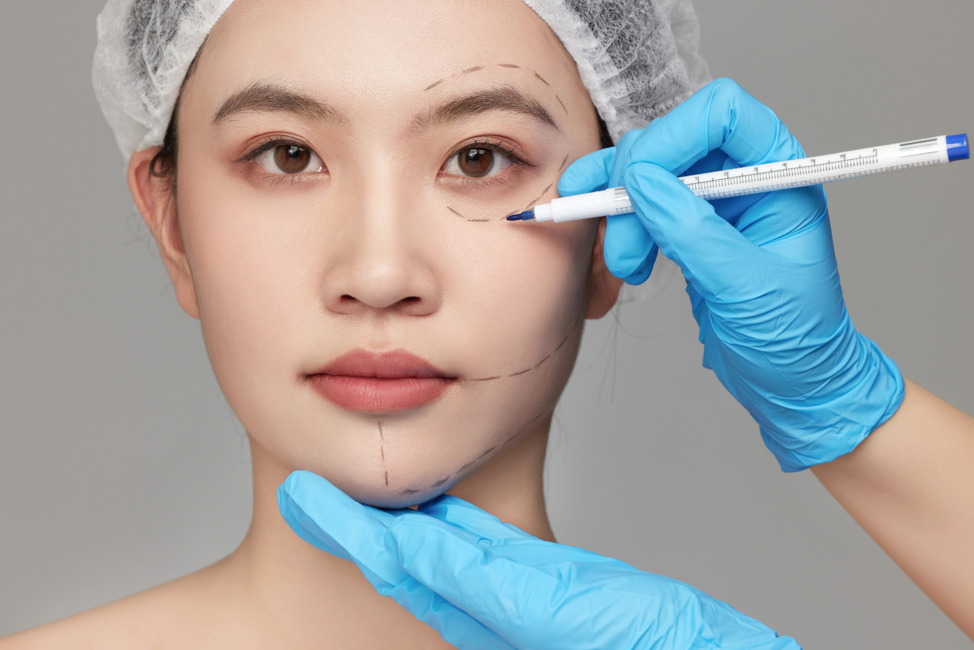 整形医生正在给女人的眉眼画上标记