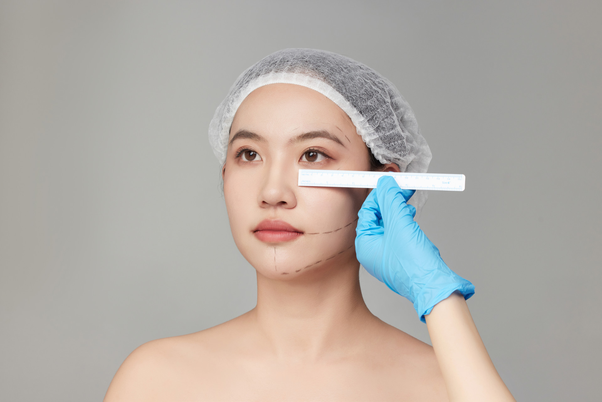 整形医生用尺子测量年轻女人的眼距